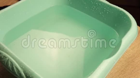 一个人把手放在盆里的清水里视频的预览图