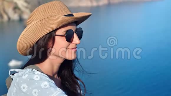 微笑的年轻女性游客放松有积极的情绪蓝色清澈的海洋背景视频的预览图
