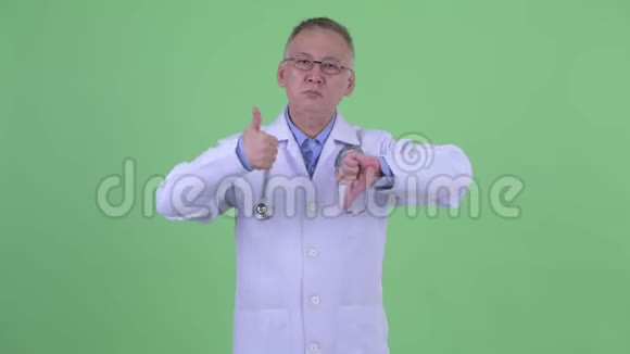 成熟的日本男医生在竖起大拇指和大拇指之间做出选择视频的预览图
