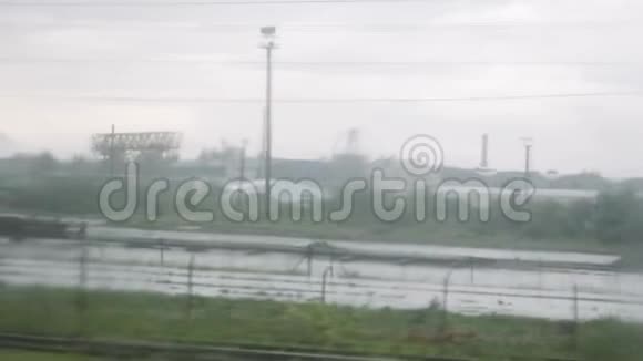 乡村景观通过移动列车窗口与水滴在玻璃上火车玻璃上的雨滴视频的预览图