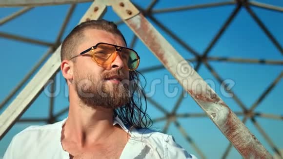 留胡子的时尚男性戴着太阳镜在网格背景下摆出一副自信的面孔视频的预览图
