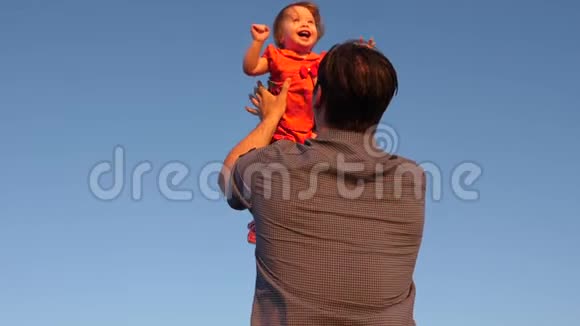 幸福的一家人晚上在天空中玩耍爸爸把他的孩子扔在蓝天上爸爸玩一点视频的预览图