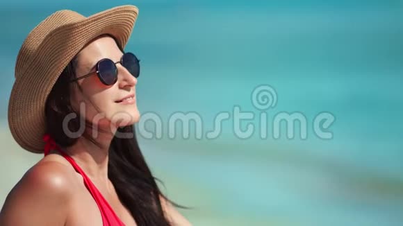 微笑旅游时尚女性戴帽子太阳镜日光浴欣赏海景有积极的情绪视频的预览图