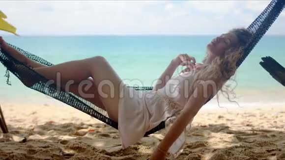 放松的女人梦想着在海滩上的吊床上闲逛视频的预览图