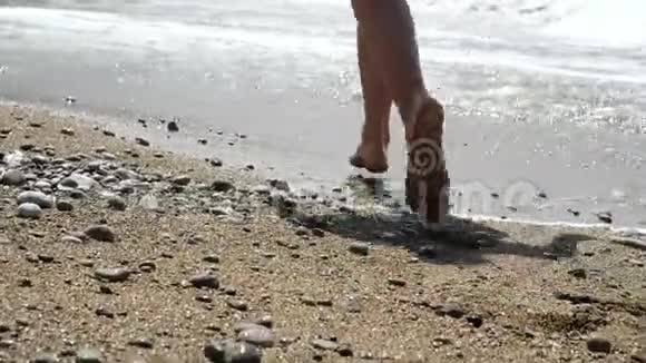 特写的女人她的脚在炎热的阳光沙滩上奔跑活跃的赤脚女人在海边的沙滩上奔跑视频的预览图