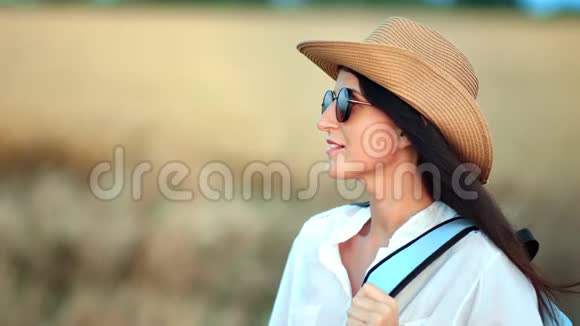 中度特写令人愉快的旅游女性在日落时享受被麦田包围的暑假视频的预览图