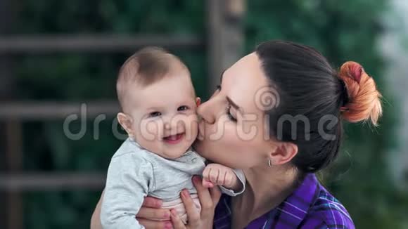 贴心可爱的妈妈有温柔的爱有亲吻她的小宝宝和微笑的感觉视频的预览图
