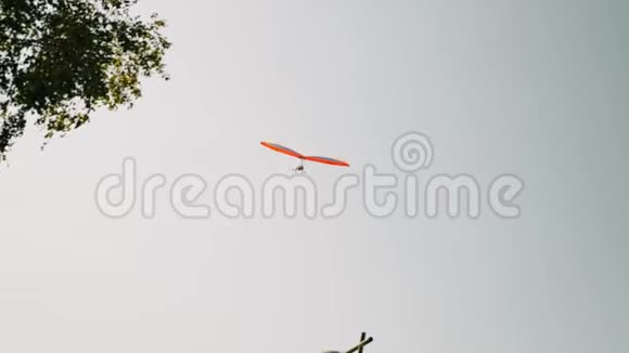 橙色孤立悬挂滑翔机在灰色多云的天空中飞行阿尔卑斯山的滑翔机飞行课程视频的预览图