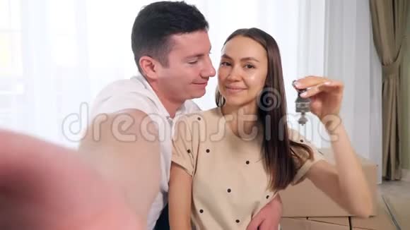 幸福的一对情侣用钥匙拍一张新房子视频的预览图