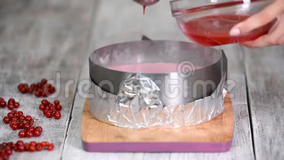 糖果师把红果冻倒在慕斯蛋糕上烹饪理念甜食视频的预览图