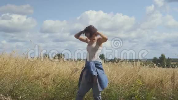 可爱的短发女人穿着紧身衣在麦田里放松女孩喜欢自然看和摆姿势视频的预览图