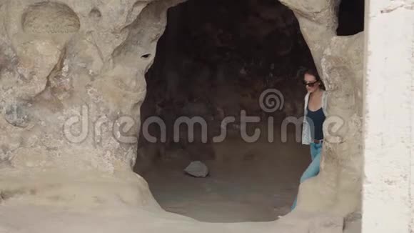 可爱的年轻女子穿着夏装戴着深色太阳镜金发碧眼游客来自格鲁吉亚的洞穴视频的预览图