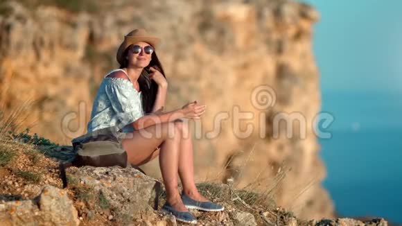 美丽的微笑徒步旅行者女性在山顶放松享受日落时的自然景色视频的预览图