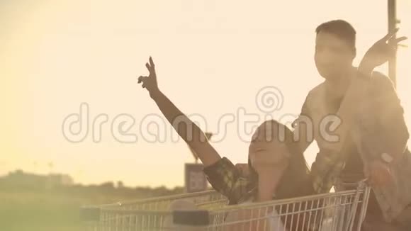 镜头耀斑快乐的人在日落时分和男人和女人在一起骑着超市里的慢动作视频的预览图