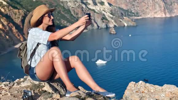 迷人的时尚旅游年轻女性自拍使用智能手机摆在山顶视频的预览图