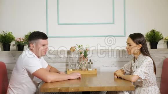 担心的男人用手指敲桌子严肃的女人在咖啡馆里视频的预览图