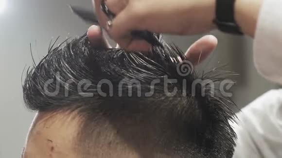 额外的特写男理发师的手梳理和剪发给客户在沙龙视频的预览图