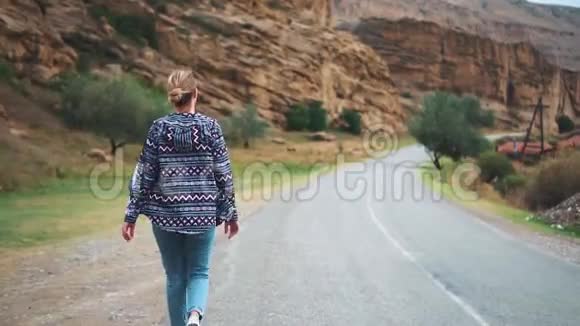 美丽可爱的女孩在乔治亚州陡峭的山下沿着公路奔跑视频的预览图