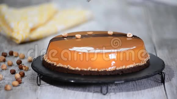 甜点女人用镜子釉装饰榛子焦糖慕斯蛋糕视频的预览图