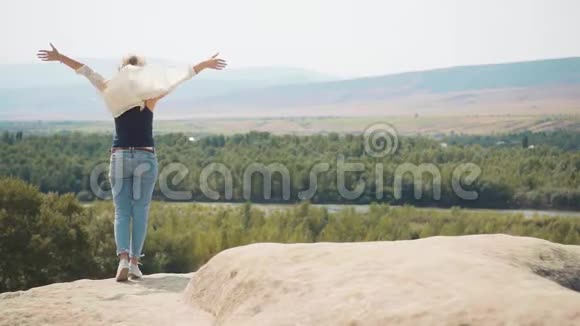 感觉在风中飞翔飘扬的头发和轻盈的夏装穿着牛仔裤和白色衬衫的女士视频的预览图