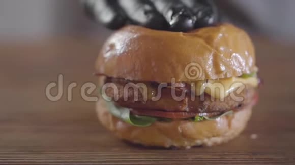 厨师的手在黑色橡胶手套压榨汉堡和酱汁流出特写美味的食物准备果汁视频的预览图
