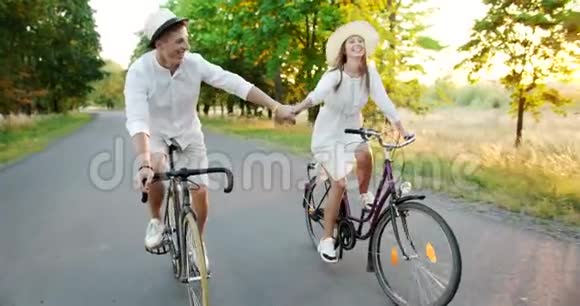 可爱的情侣骑自行车手牵手视频的预览图