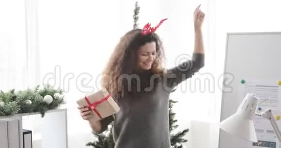 女人在办公室跳舞庆祝圣诞节视频的预览图