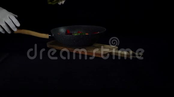 厨师把盐和橄榄油加入到黑底锅中煮的食物中视频的预览图