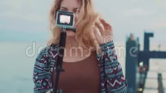 一个视频博客作者和旅行者的幸福生活一个漂亮的漂亮女孩在相机上摆姿势快乐地跳跃和大笑视频的预览图
