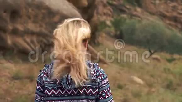 年轻的女士穿着一件时髦的紫色毛衣正在山里散步这位女士正在佐治亚州徒步旅行她的长发视频的预览图