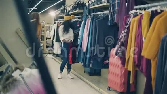 快乐的女士在购物时选择衣服视频的预览图