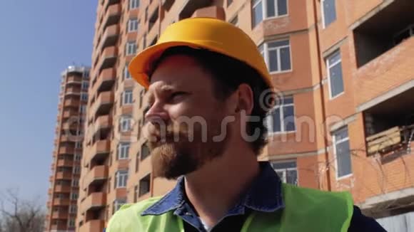 施工管理人员戴黄色安全帽留胡须和胡子顶着施工现场说话4千克视频的预览图