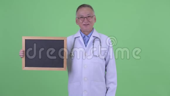 快乐成熟的日本男医生拿着黑板竖起大拇指视频的预览图