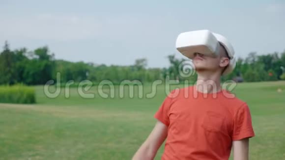一名男子在公园里使用VR耳机躲避障碍物环顾四周视频的预览图
