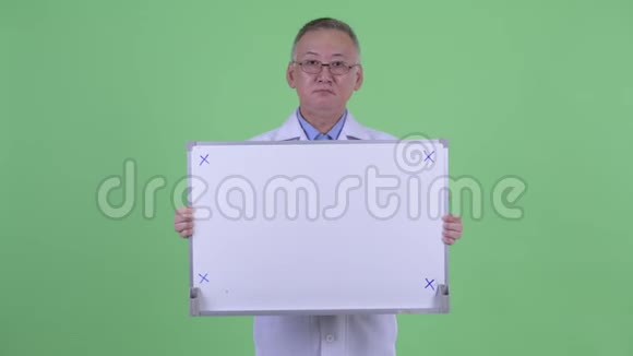 快乐成熟的日本男医生拿着白板思考视频的预览图
