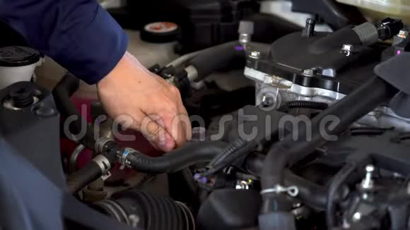 技师检查汽车发动机油尺油位的手视频的预览图