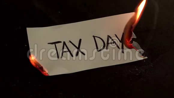 纳税日字样写在白纸上燃烧带着烟雾和灰烬的火焰视频的预览图