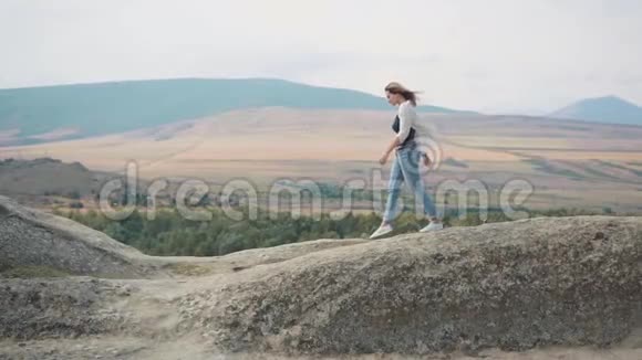 迷人的年轻女子一头金发穿着轻盈的夏装在大风中飞翔从佐治亚州的顶端下来快乐视频的预览图