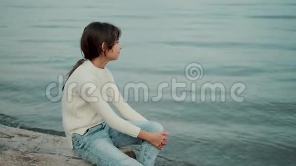 小孩坐在海边享受美丽的景色视频的预览图
