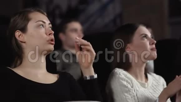 三个漂亮的女朋友正在电影院吃爆米花和看电影视频的预览图