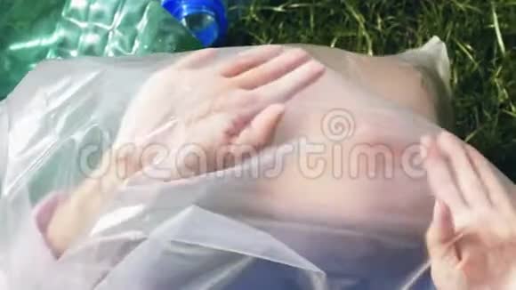塑料污染的概念片段女人躺在塑料袋里视频的预览图