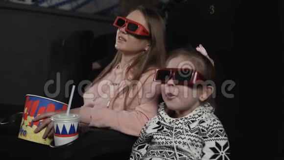 妈妈和女儿正在电影院看3d电影情感惊喜视频的预览图