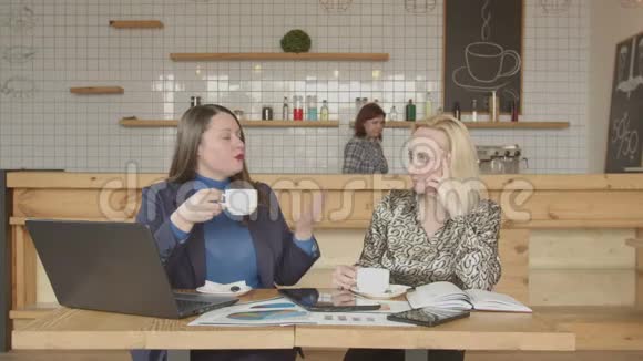 女商人在自助餐厅喝咖啡聊天视频的预览图