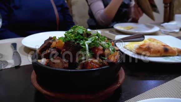 奥贾胡里格鲁吉亚一家餐馆的泥锅里的土豆和草药视频的预览图