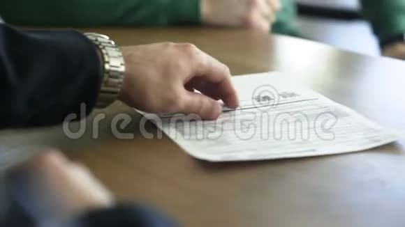 男子在检查条款和条件后签署汽车保险合同视频的预览图