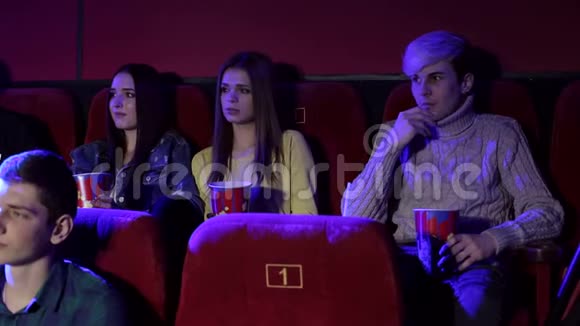 青少年在电影院看一部悲伤的电影视频的预览图