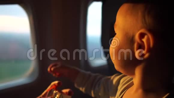 在太阳的黎明妈妈带着一个孩子坐在飞机的窗户前视频的预览图