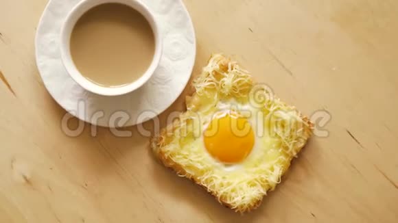 木制厨房桌子上有煎鸡蛋和咖啡的烤面包片视频的预览图