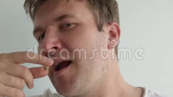一个人吞下一颗白药丸用水喝视频的预览图