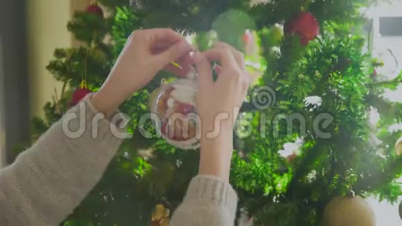 用彩球装饰圣诞树的女人的手视频的预览图